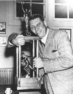 Auburn football coach Shug Jordan hugging the 1957 AP poll trophy